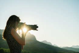Young female photographer taking photos of beautiful nature